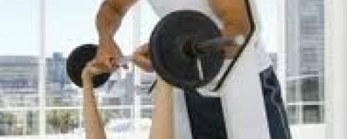 Trainer Spotting Client During Bench Press Exercise